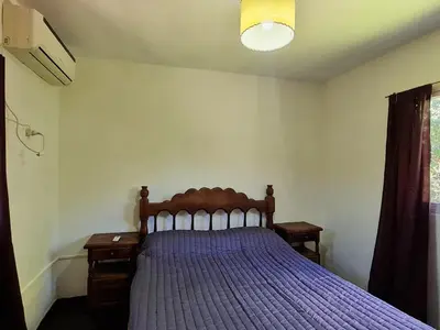 a bedroom with a bed with a purple bedspread at La Armonía Departamentos in Merlo