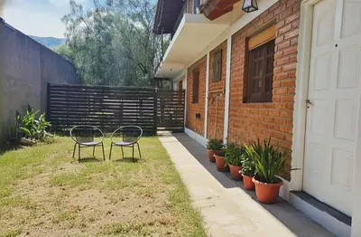 two chairs sitting on the side of a house at La Armonía Departamentos in Merlo