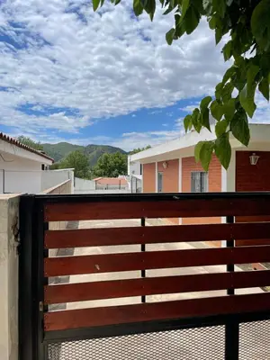 a wooden fence with a view of a building at Areté Del Rio in Villa Carlos Paz