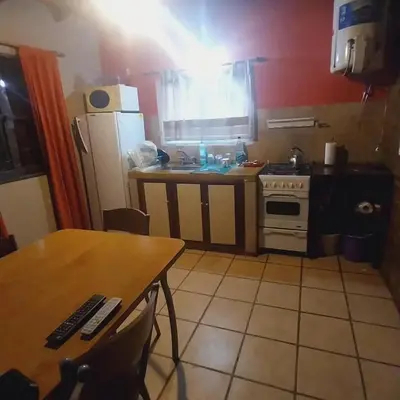 a small kitchen with a table and a stove at Casas de alquiler villa ciudad parque in Villa Ciudad Parque