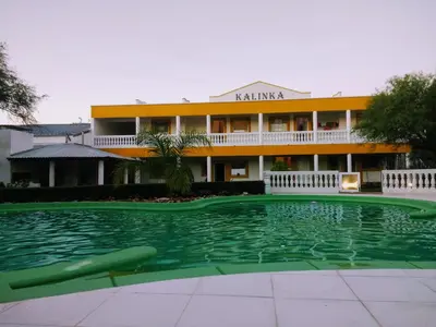 a swimming pool in front of a building at Complejo Kalinka in Carpintería