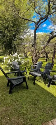 a group of park benches sitting in the grass at Complejo Kalinka in Carpintería