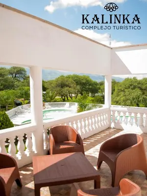 a balcony with chairs and a table and a pool at Complejo Kalinka in Carpintería