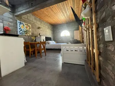 a room with a bedroom with a bed and a table at Monoambiente luminoso y equipado, ubicado en zona céntrica in Cordoba