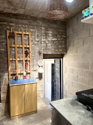 a kitchen with a wooden cabinet and a brick wall at Monoambiente luminoso y equipado, ubicado en zona céntrica in Cordoba