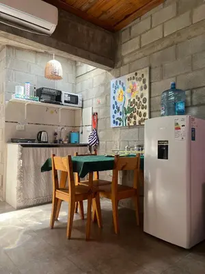 a kitchen with a table with chairs and a refrigerator at Monoambiente luminoso y equipado, ubicado en zona céntrica in Cordoba
