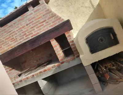 a brick pizza oven sitting on the side of a building at Complejo gauna in Villa Carlos Paz