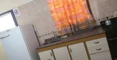 a kitchen with a sink and a refrigerator at Complejo gauna in Villa Carlos Paz