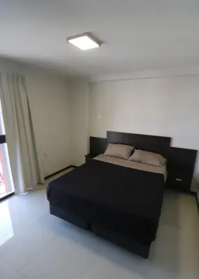 a bedroom with a black bed in a room at DEPARTAMENTO con PILETA CENTRO CARLOS PAZ in Villa Carlos Paz
