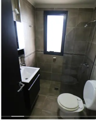 a bathroom with a toilet and a sink and a shower at DEPARTAMENTO con PILETA CENTRO CARLOS PAZ in Villa Carlos Paz