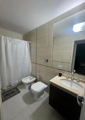 a bathroom with a toilet and a sink and a mirror at Ruptura in Villa Carlos Paz