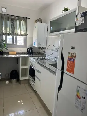 a kitchen with white cabinets and a refrigerator at Ruptura in Villa Carlos Paz