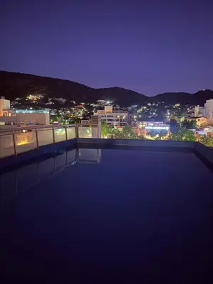 a swimming pool with a view of a city at night at Ruptura in Villa Carlos Paz