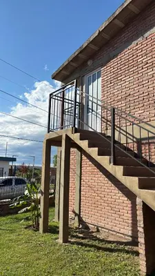a brick building with a staircase on the side of it at Departamento Vilma Planta Alta Brochero in Villa Cura Brochero
