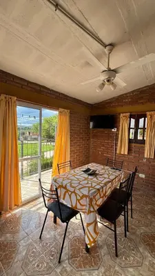 a dining room with a table and chairs and a window at Departamento Vilma Planta Alta Brochero in Villa Cura Brochero