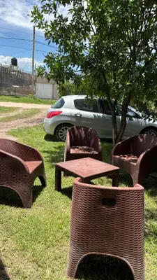 a picnic table and chairs in the grass near a car at Departamento Vilma Planta Alta Brochero in Villa Cura Brochero