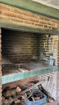 a brick fireplace with two baskets on the floor at Departamento Vilma Planta Alta Brochero in Villa Cura Brochero