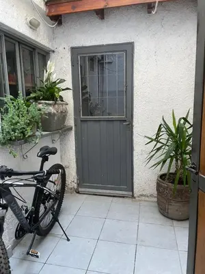 a bike parked in front of a house with a door at Habitación Individual con todas las comodidades in Cordoba