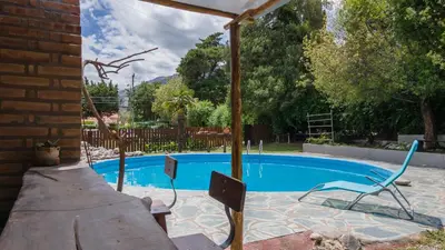 a swimming pool with two chairs and a table at ASM Apart IX in Merlo