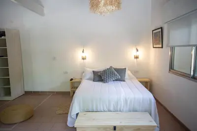 a bedroom with a bed with white sheets and pillows at ASM Apart IX in Merlo
