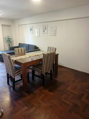 a dining room table with two chairs and a couch at departamento velez 372 in Cordoba