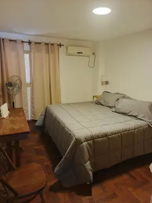 a bedroom with a bed and a table with a fan at departamento velez 372 in Cordoba