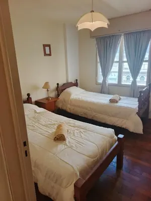 a hotel room with two beds and a window at Departamento 2 dorm frente patio olmos in Cordoba