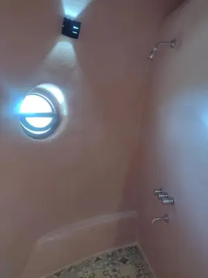 a bathroom with a toilet with a light on the wall at Cabañas Las Luciérnagas in San Javier