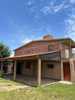an old brick building with a balcony on top at Departamento Vilma Planta Baja Brochero in Villa Cura Brochero