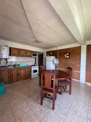 a kitchen with a table and chairs and a refrigerator at Departamento Vilma Planta Baja Brochero in Villa Cura Brochero