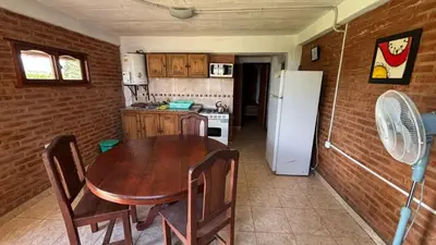 a kitchen with a wooden table and a refrigerator at Departamento Vilma Planta Baja Brochero in Villa Cura Brochero