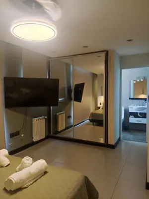 a large mirror in a room with a bed and a bedroom at Comfort and Location in Río Cuarto