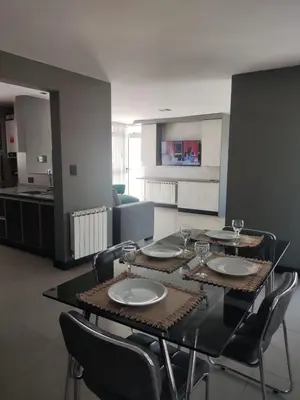 a dining room with a table and chairs with wine glasses at Comfort and Location in Río Cuarto