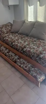 a bed with a wooden frame with flowers on it at Departamento con inmejorable ubicacion en Villa Carlos Paz in Villa Carlos Paz