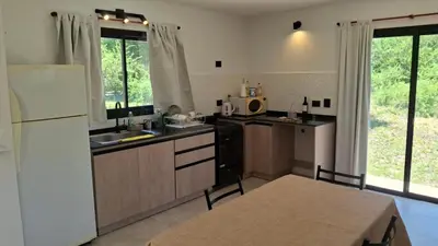a kitchen with a white refrigerator and a sink at Hermosa Casa Moderna en el Mirador del Lago in Bialet Massé
