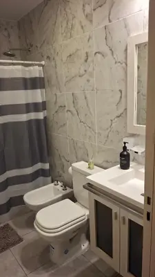 a bathroom with a toilet and a sink and a shower at Hermosa Casa Moderna en el Mirador del Lago in Bialet Massé
