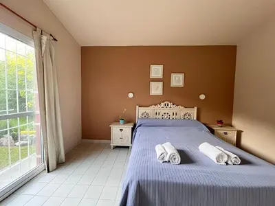 a bedroom with a bed and a large window at Rocco Housse in Los Hornillos