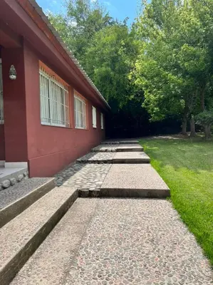 a brick walkway next to a red building at Rocco Housse in Los Hornillos