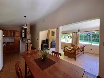 a kitchen and living room with a wooden table and chairs at Rocco Housse in Los Hornillos
