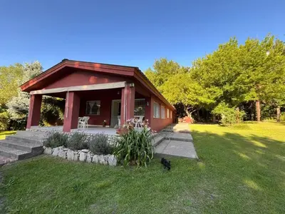 a small red house with a cat in the yard at Rocco Housse in Los Hornillos