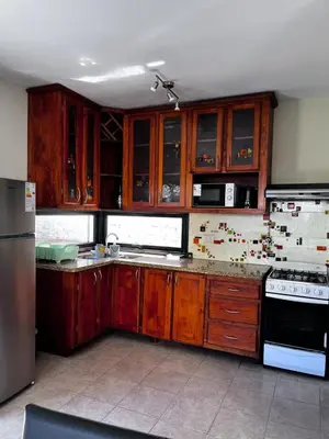 a kitchen with wooden cabinets and a refrigerator at Shakti in Almafuerte