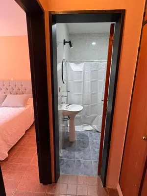 a bathroom with a bed and a sink and a shower at Complejo Zara in Villa Carlos Paz