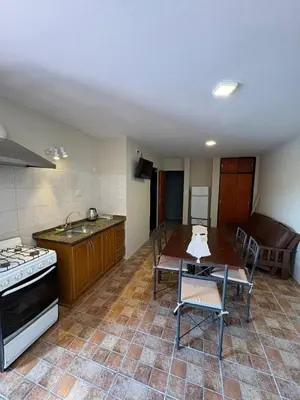 a kitchen with a sink and a table and a stove at Complejo Zara in Villa Carlos Paz