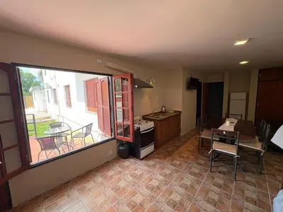 a kitchen with a large window and a table and chairs at Complejo Zara in Villa Carlos Paz