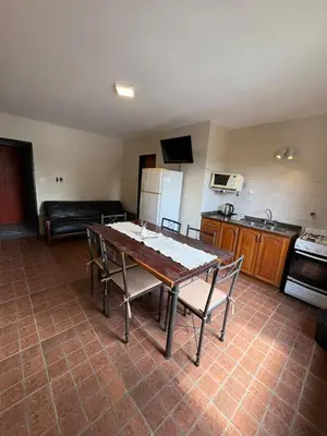 a kitchen with a table and chairs in a room at Complejo Zara in Villa Carlos Paz