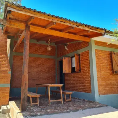 a wooden pergola with a picnic table on a patio at Complejo Ayllu in Las Rabonas