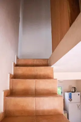 a staircase in a house with a white refrigerator at Alma Petra - Cabañas en Cabalango, Tanti, Punilla in Estancia Vieja