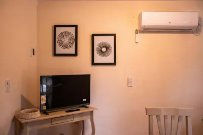 a flat screen tv on a wall with three pictures at Alma Petra - Cabañas en Cabalango, Tanti, Punilla in Estancia Vieja