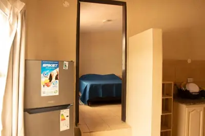 a mirror in a kitchen with a refrigerator in a room at Alma Petra - Cabañas en Cabalango, Tanti, Punilla in Estancia Vieja