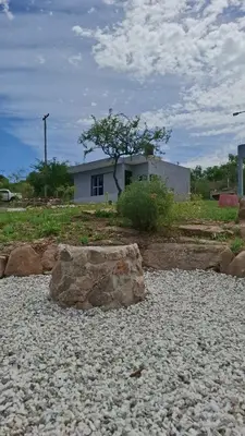 a rock sitting on the ground in front of a house at Entre Sierras Cabañas in Tanti